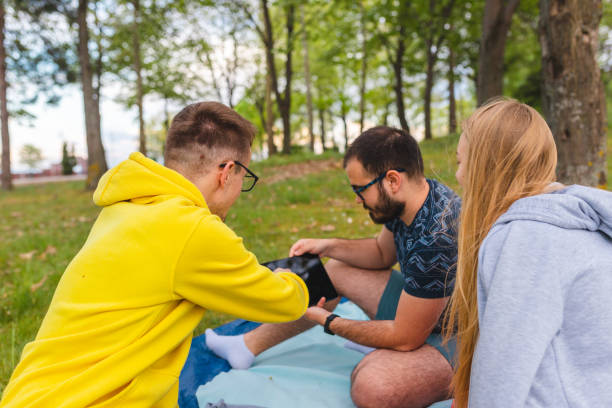 istock Close-up of three young friends laughing while using tablet in nature 1394276967