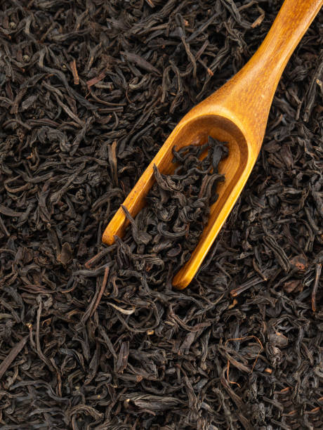 istock dry black tea leavs background and wooden spoon 1394277758