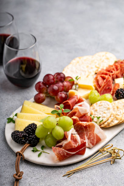летняя чаркутерная доска с сыром, мясом и фруктами - wine cheese food salami стоковые фото и изображения