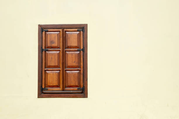 a wooden decorative window on cream painted wall stock photo