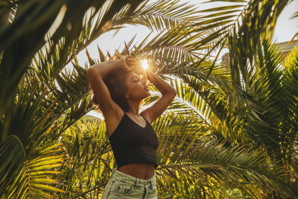istock Pretty young afro woman among palm trees 1394283094