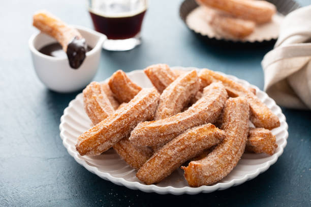 churros caseros con azúcar de canela en un plato - churro chocolate cup sweet food fotografías e imágenes de stock