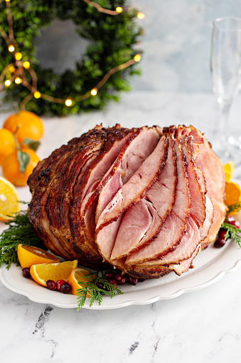 Spiral sliced Christmas ham with orange honey glaze on a serving plate