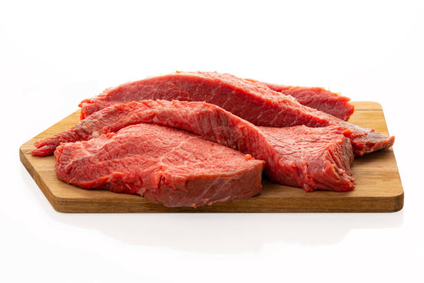 istock Fresh beef, cut into several pieces, lies on a kitchen cutting board. Isolated on white. Concept. 1394284254
