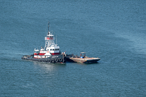 Charleston, SC, USA - April 28, 2022: Elizabeth Ann, a 30-meter, 3,000-horsepower tugboat owned by Norfolk Dredging Company, pushes a barge in Charleston Harbor.