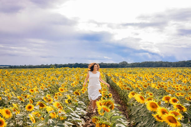 istock Girl runs in a sunflower field 1394284562