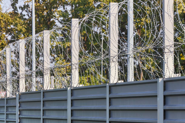Spiral barbed wire on the fence protects against penetration stock photo