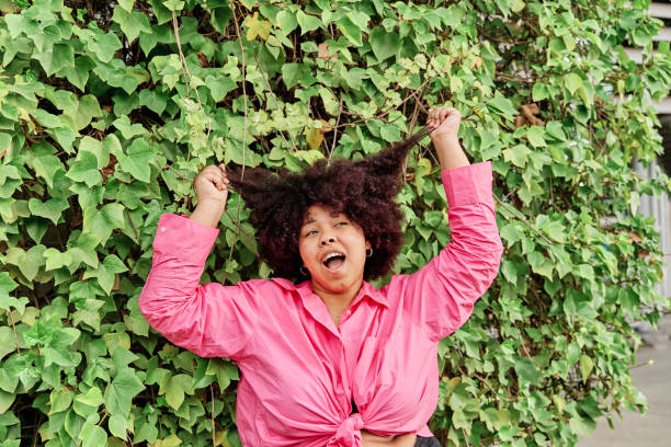 istock young african american woman pulls her hair curly 1394287903