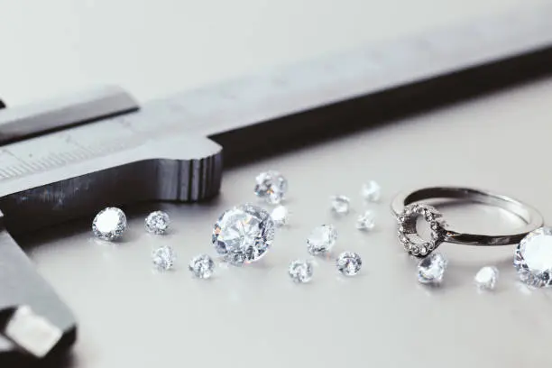 Photo of Workplace of a jeweler. Tools and equipment for jewelry work on an metal desktop. Jeweller at work on jewelry made of diamonds. Platinum Diamond Metal Background