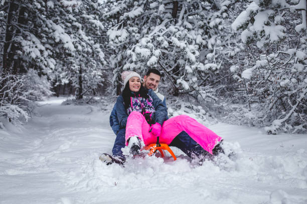 istock Couple sledding and playing like a kids in the snow 1394290835