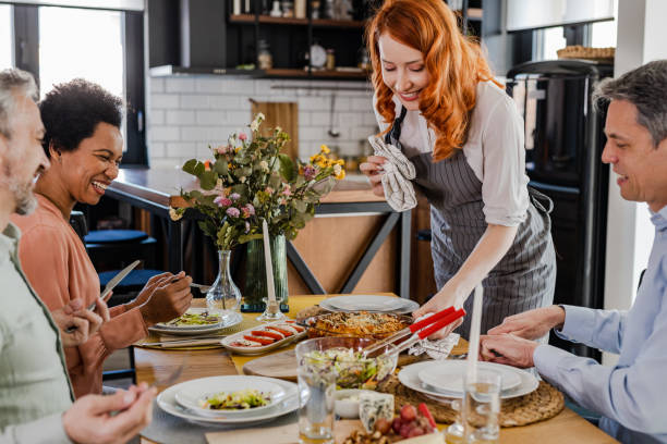 istock Woman brings food on the table during dinner 1394291892