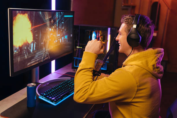 istock Exited cyber sportsman makes winner hand gesture while playing computer game 1394295807