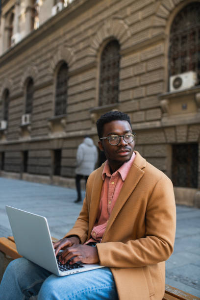 istock Portrait of an attractive black man using a laptop outside 1394299873
