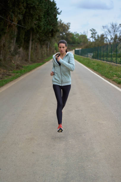 istock woman running down the street in the forest front view 1394299919