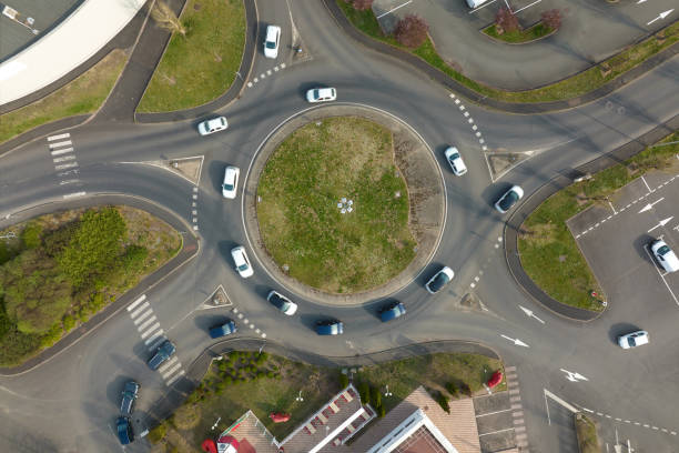 Aerial view of road roundabout intersection with fast moving heavy traffic. Urban circular transportation crossroads Aerial view of road roundabout intersection with fast moving heavy traffic. Urban circular transportation crossroads. traffic circle photos stock pictures, royalty-free photos & images