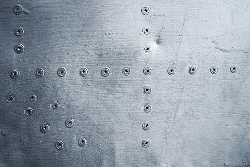 Close-up blue painted metal panel with screw, background texture, rivets, dots, part of old plane