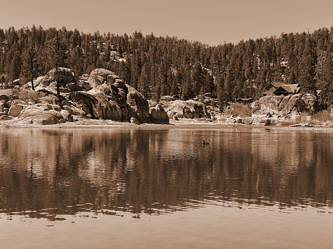 a sepia lake shore reflections vintage photograph shoreline pier clear water edge blue sky lakeside forest mountains reflection
