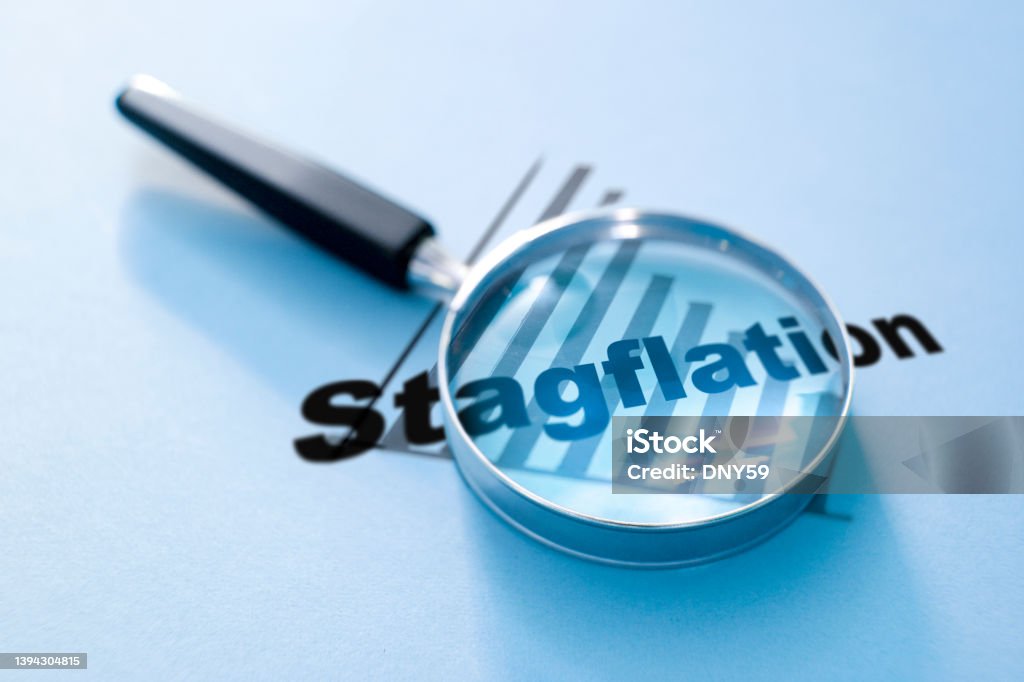 Stagflation A magnifying glass rests on top of a downward sloping chart with the word stagflation on top of it. Stagflation Stock Photo