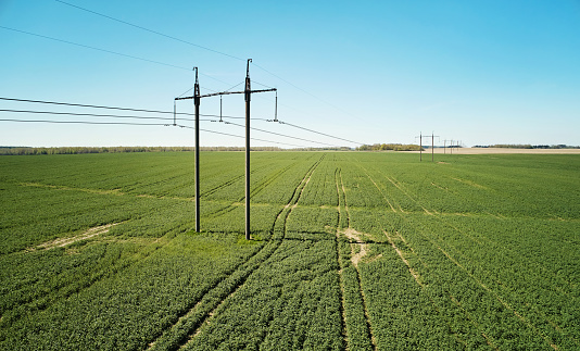 Pylon of  electric line on green field aerial drone view