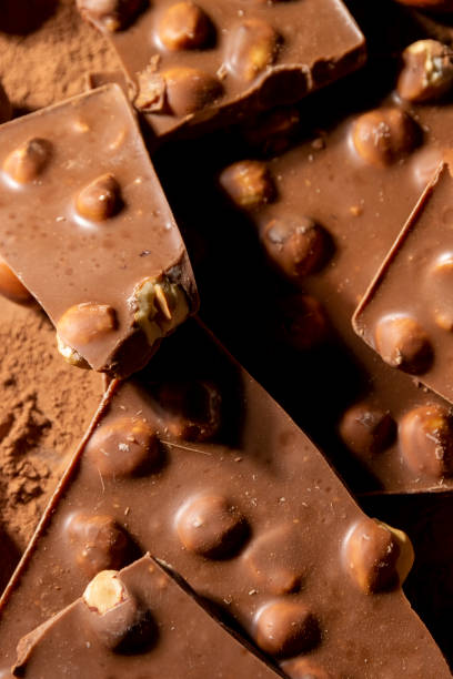 istock Dark chocolate background by chocolate pieces, and cocoa powder 1394316609