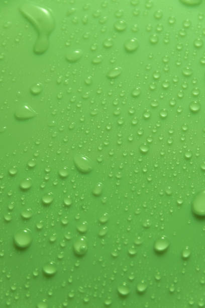 istock Green pastel water drops on light shiny surface 1394316668