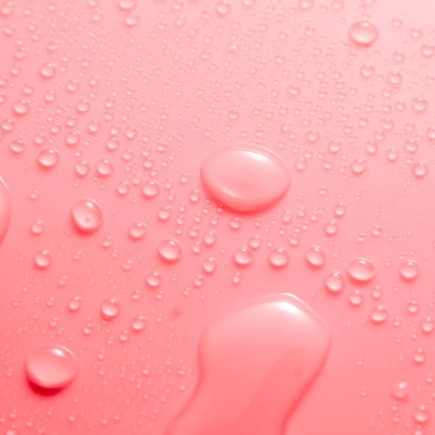 istock Pink pastel water drops on light shiny surface 1394316673