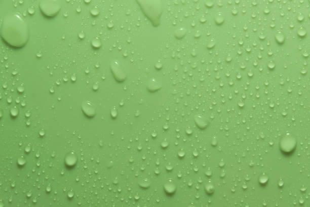 istock Green pastel water drops on light shiny surface 1394316680