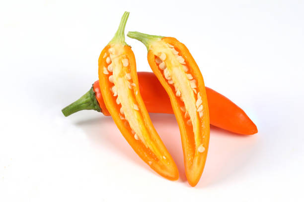 Fresh orange chilli, halved on a white background close-up view on white