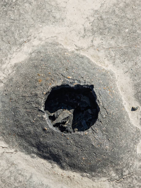 istock A ball has formed in the asphalt, which has burst. Deep hole in the asphalt. 1394330819