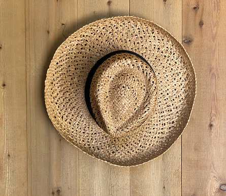 Straw hat hanging on wood wall rustic