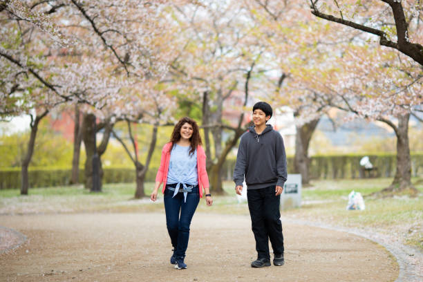 istock Mother with her son in cherry blossom park 1394332888