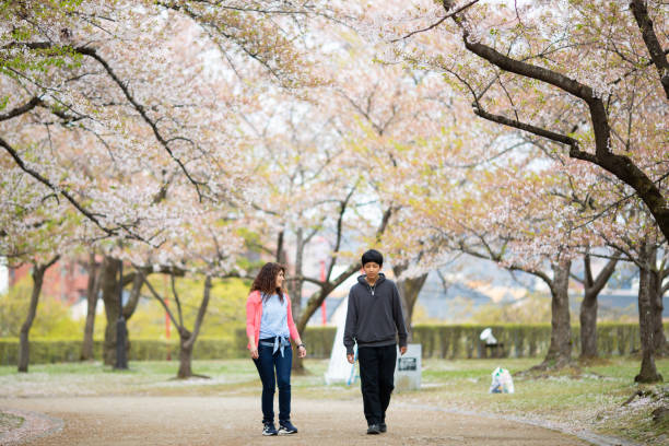 istock Mother with her son in cherry blossom park 1394332889