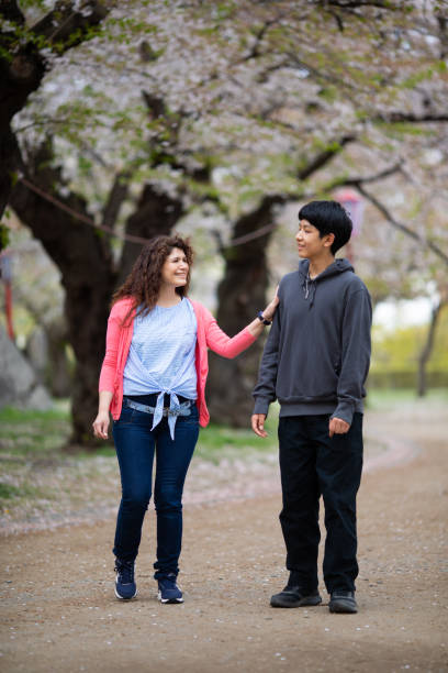 istock Mother with her son in cherry blossom park 1394332902