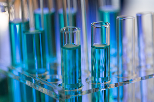 Neatly arranged test tubes containing blue reagent in chemistry laboratory - stock photo