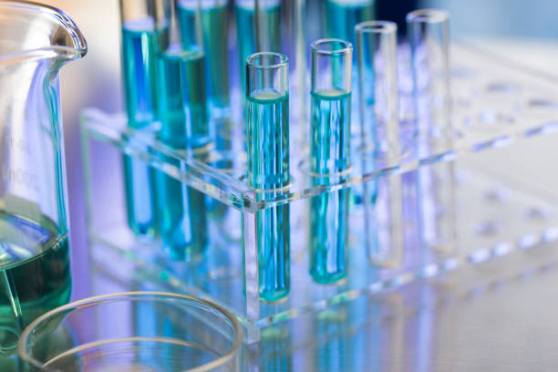 istock Neatly arranged test tubes containing blue reagent in chemistry laboratory with beaker and petri dishe - stock photo 1394332944