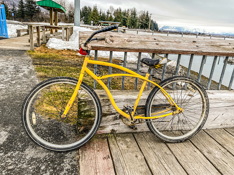 A yellow bike stands at the ready. Sitting at the pier, this bike is ready for adventure.