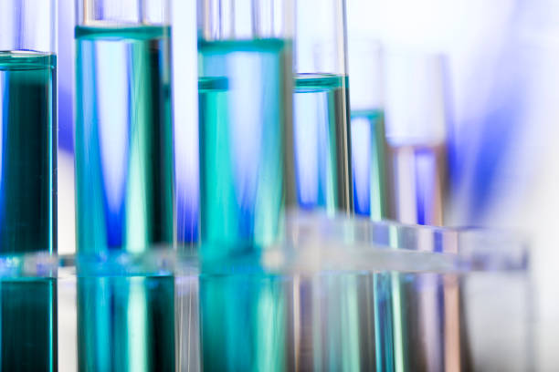 neatly arranged test tubes containing blue reagent in chemistry laboratory - stock photo - reagent imagens e fotografias de stock