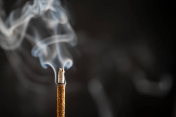 Asian incense stick burning with smoke, close up, macro