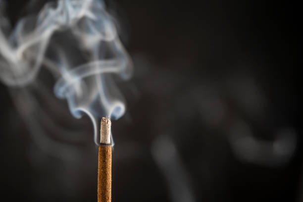 Asian incense stick burning with smoke, close up, macro stock photo