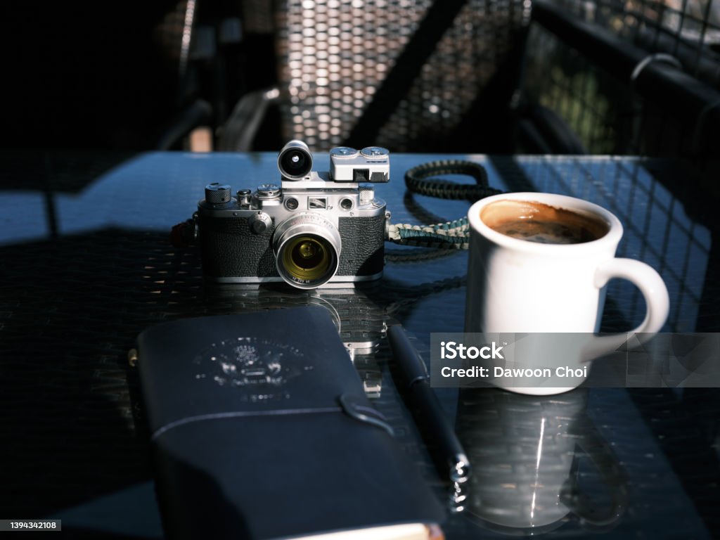 A customized classic film camera with a cup of coffee. Antique Stock Photo