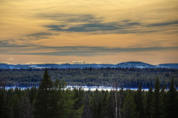 Beautiful cloudscape and orange sky over winter mountains.