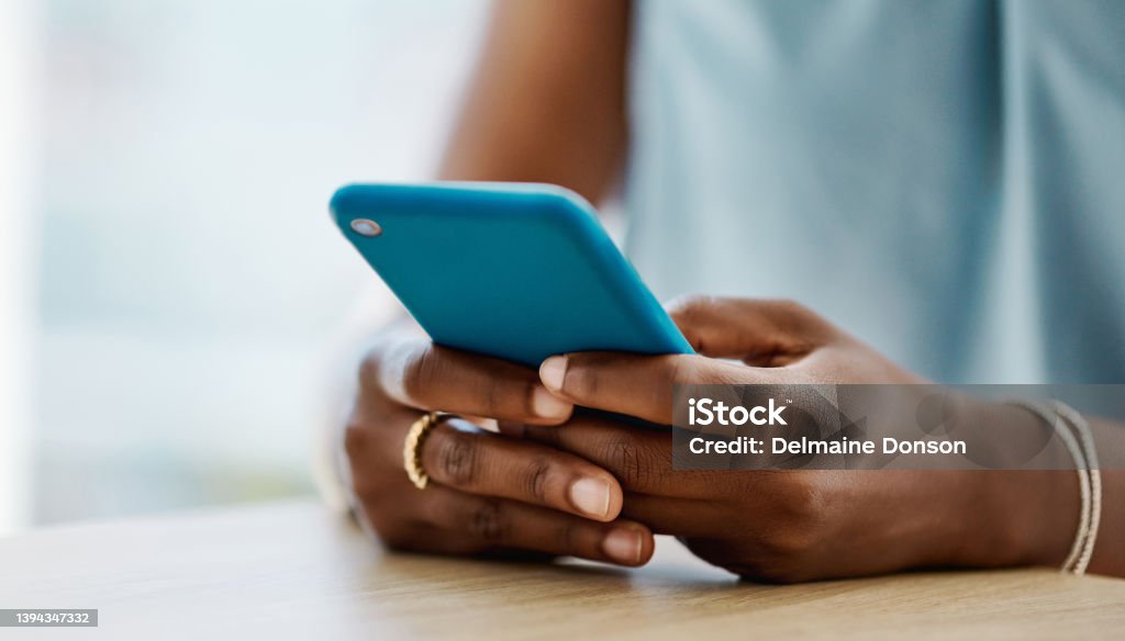 African woman using a cellphone in an office alone Mobile Phone Stock Photo