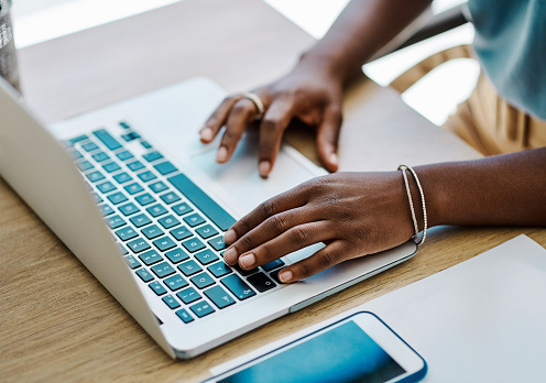 African businesswoman doing research and planning on a laptop in an office alone