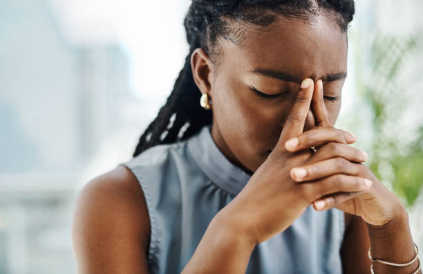 istock Black businesswoman dealing with a headache and feeling stressed while working in an office alone 1394347485