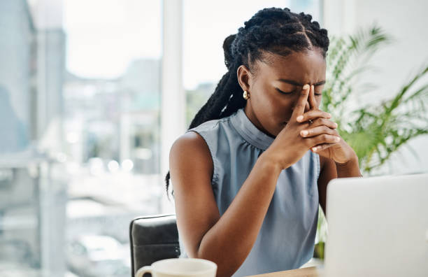 gestresste schwarze geschäftsfrau, die allein in einem büro an einem laptop arbeitet - frustration office worker women business stock-fotos und bilder