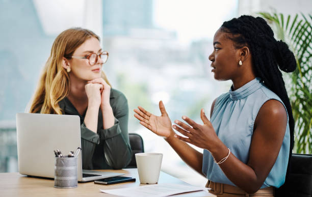 istock Two diverse businesswomen having a discussion to share ideas and plans while working together in an office 1394348679