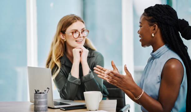 istock Two happy diverse businesswomen having a discussion while working together in an office 1394348680
