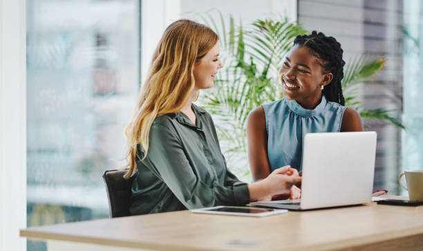 istock Two young businesswomen discussing their plans and ideas while working together on a laptop in an office 1394348687