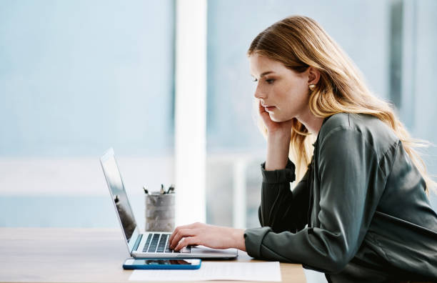 Free Stock Photo of A young blonde woman working on her laptop ...
