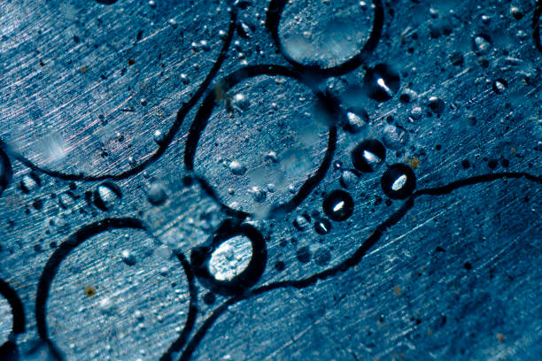 Blue oil and water bubbles floating in steel pan